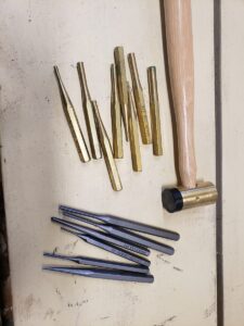 Brass hammer with an assortment of brass and steel punches.