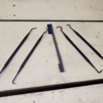 A set of four plastic picks around a nylon brush for cleaning guns.